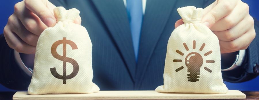 bag with dollar sign on scale with bag withlightbulb